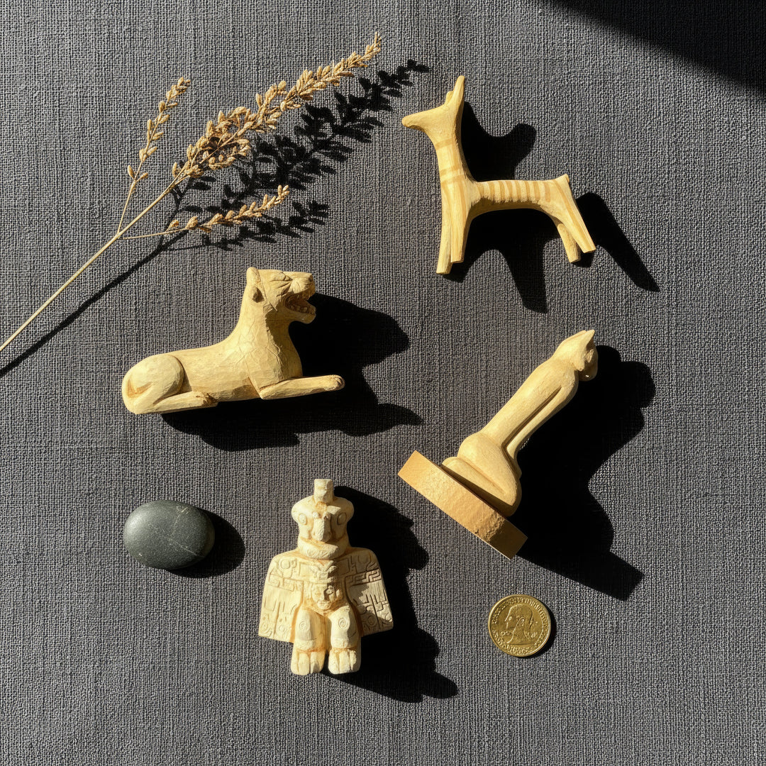 Top view of the Ancient Animal Guardian Set surrounded by vintage archaeological objects — handmade replicas of the Aztec Condor Warrior, Urartian Lion, Mycenaean Dog, and Calusa Marco Cat placed among old maps, stone fragments, and dried herbs. Artistic flatlay capturing ancient symbolism and boho aesthetic by ArkeoArt.