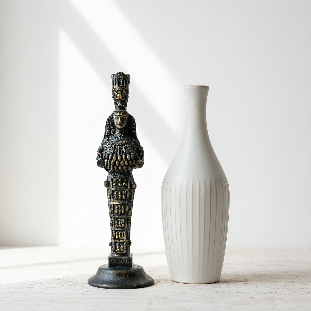 “Ephesus Artemis statue displayed beside a large decorative vase on a wooden table. The contrast between the handmade ceramic and the ancient goddess sculpture highlights a balance of divine femininity and artistic craftsmanship — a perfect centerpiece for boho or spiritual interiors.”
TR:
“Ahşap bir masa üzerinde büyük bir dekoratif vazonun yanında sergilenen Efes Artemis heykeli. El yapımı seramikle antik tanrıça figürünün yarattığı kontrast, tanrısal dişiliğin ve sanatsal el işçiliğinin dengesini vurgula