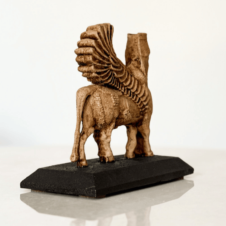 Lamassu heykelinin arka yüzü, kartal kanatlarının tüy detayları ve aşağıya doğru inen kuyruk yapısıyla gösterilmiştir. Kaidesiyle birlikte bütünlük sağlayan bu açı, Asur’un mitolojik sembollerinde yer alan hareket hissini ve göksel koruma kavramını yansıtır. Koruyucu figür, antik doğu kültürlerini yansıtan arkeolojik replikalar arasında önemli yer tutar.
