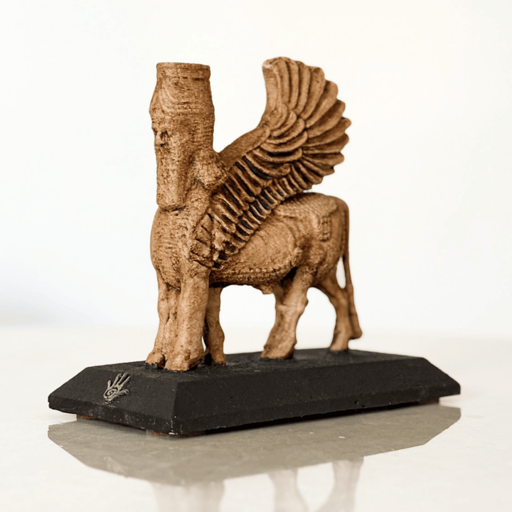 Asur mitolojisine ait insan başlı kanatlı boğa figürü olan Lamassu heykeli, çapraz açıdan detaylı şekilde görüntülenmiştir. Mat siyah kaidesinde ArkeoArt logosu yer alır. Bu dekoratif Lamassu heykeli, antik Mezopotamya sanatını temsil eder ve hem spiritüel dekor hem de koleksiyon objesi olarak öne çıkar. Kanatlı boğa heykeli, koruyucu simge olarak ev ve ofis dekorasyonunda kullanılabilir.
