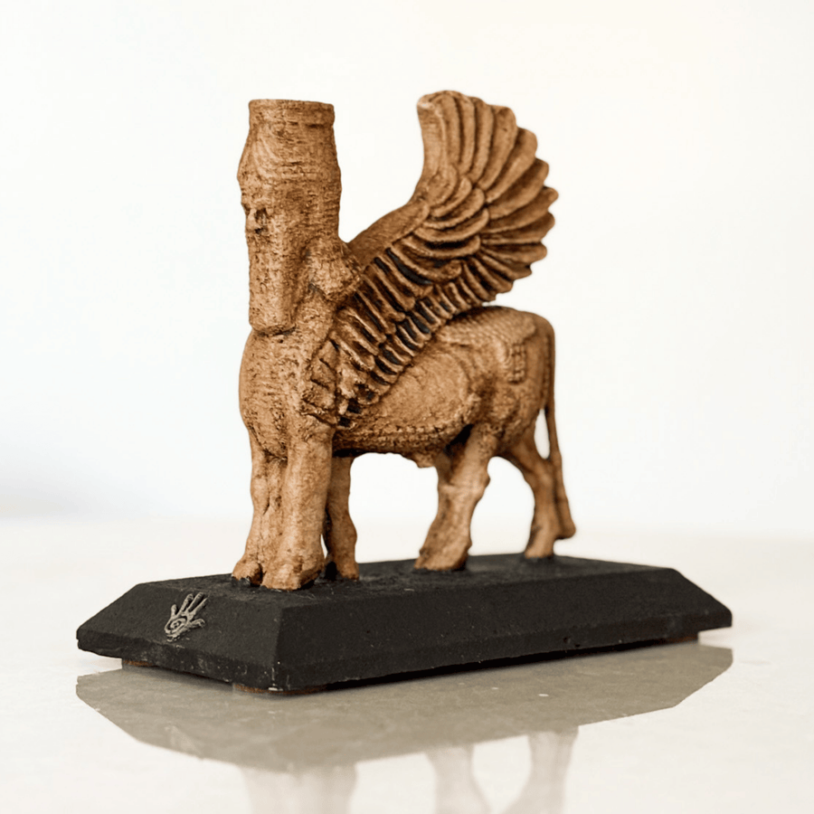 Asur mitolojisine ait insan başlı kanatlı boğa figürü olan Lamassu heykeli, çapraz açıdan detaylı şekilde görüntülenmiştir. Mat siyah kaidesinde ArkeoArt logosu yer alır. Bu dekoratif Lamassu heykeli, antik Mezopotamya sanatını temsil eder ve hem spiritüel dekor hem de koleksiyon objesi olarak öne çıkar. Kanatlı boğa heykeli, koruyucu simge olarak ev ve ofis dekorasyonunda kullanılabilir.