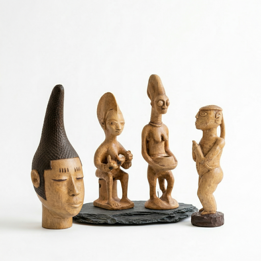 Stand üzerinde birlikte sergilenen Batı Afrika heykel seti. Yoruba kültürü anne figürü, ritüel sunu heykeli, Senufo kadın figürü ve Benin kraliyet başı ile Afrika sanat koleksiyon dekoru – ArkeoArt.