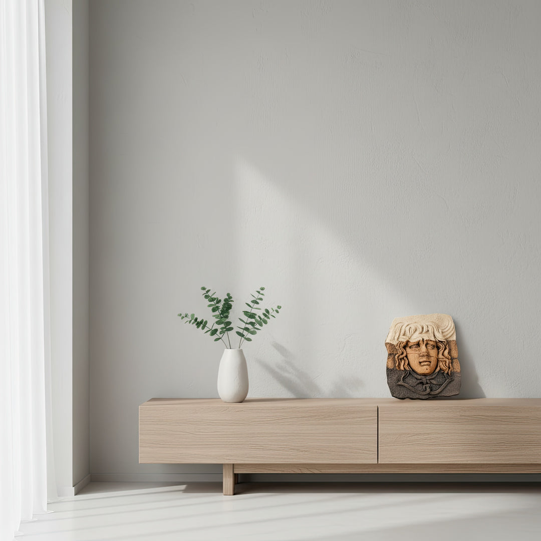 “Medusa relief sculpture displayed on a wooden sideboard in a minimalist living space with natural light. A refined blend of mythological art and modern home aesthetics.”
TR:
“Doğal ışık alan minimalist bir yaşam alanında, ahşap sehpa üzerinde sergilenen Medusa rölyefi. Mitolojik sanat ile modern ev estetiğinin zarif bir birleşimi.”