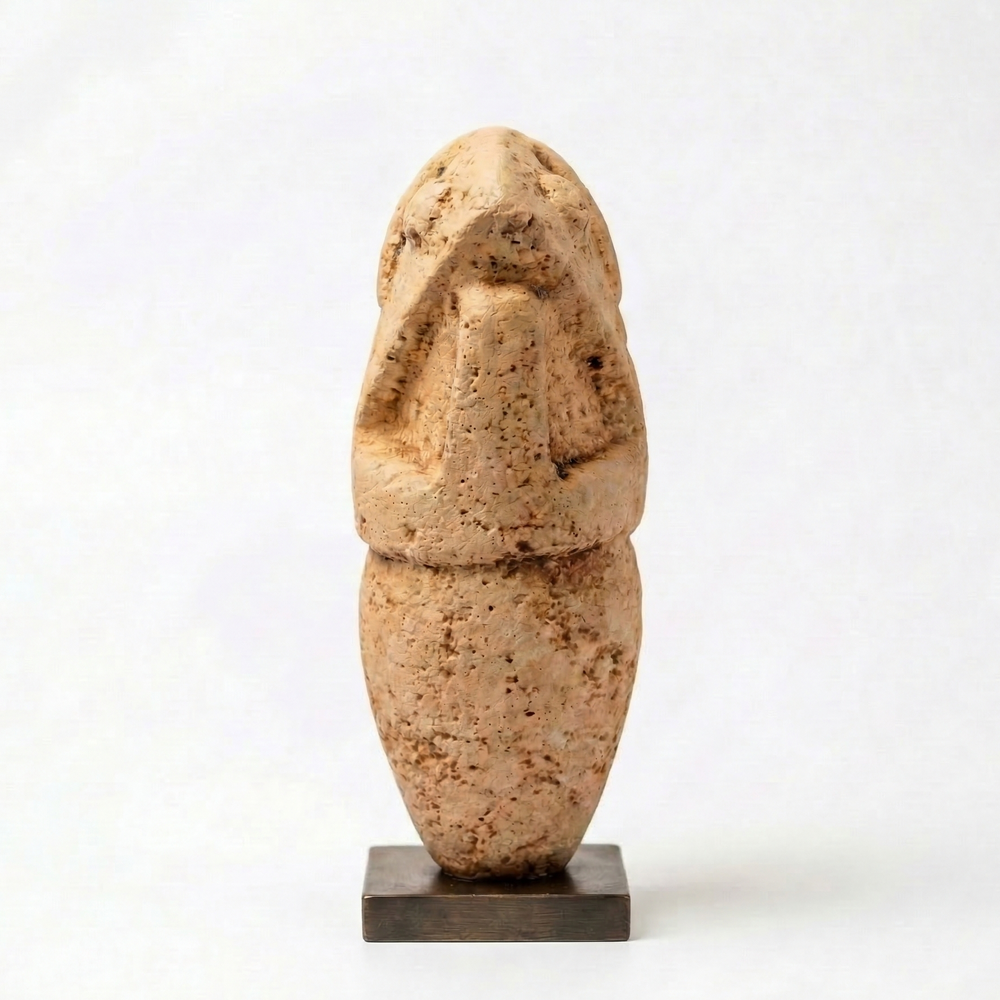 Neolitik antropomorfik idol heykeli replikası yan profilden beyaz arka plan üzerinde sergilenmektedir. Antik Anadolu ve Kiklad stilinden ilham alan bu müze kalitesinde arkeolojik figür, geometrik formu ve sade hatları ile dikkat çeker. Taş dokulu yüzeyi ve minimalist estetiği sayesinde koleksiyon, kitaplık ve ofis dekoru için ideal bir parçadır.