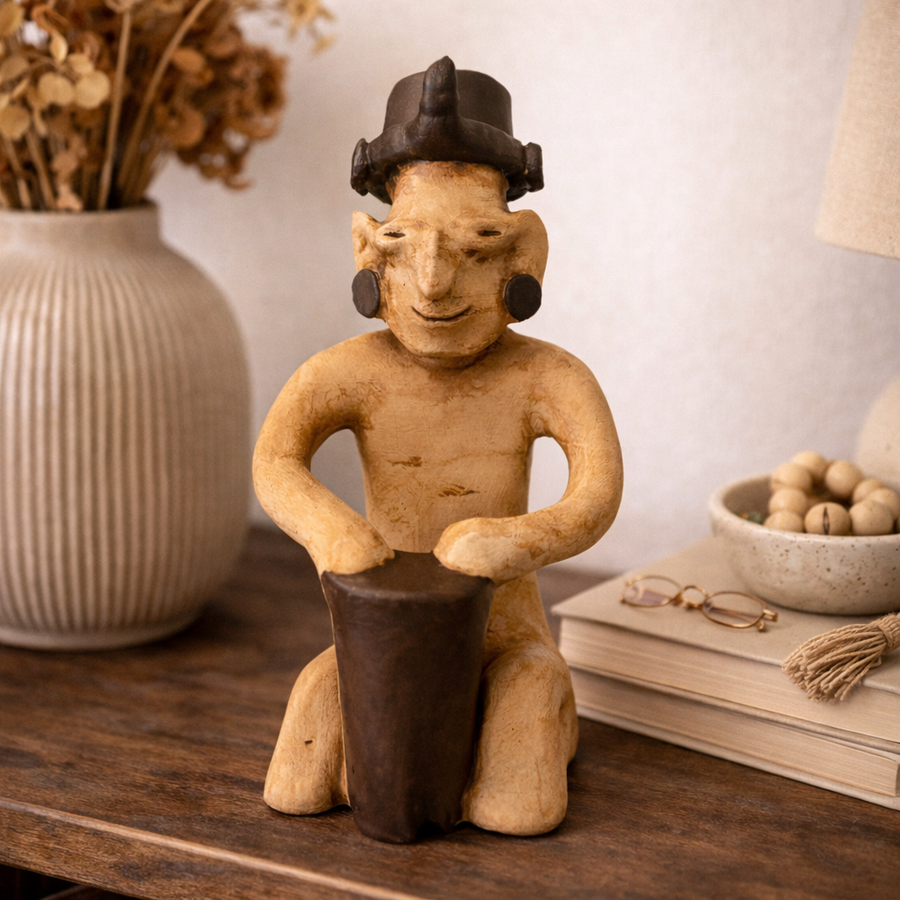 Pre-Columbian Jalisco davulcu figürü replikası dekoratif bir raf üzerinde lifestyle ortamda sergilenmektedir. Jalisco kültüründen ilham alan bu müze kalitesinde arkeolojik figür, antik seramik görünümü ve ritüel müzik temasıyla iç mekanlara özgün ve kültürel bir karakter katar.