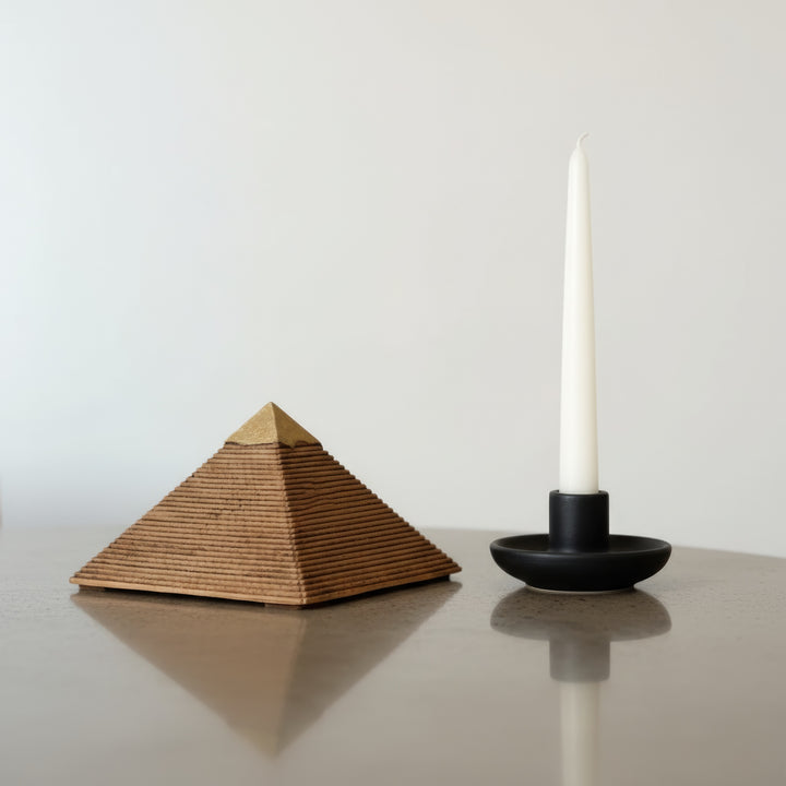 Mum ışığıyla aydınlatılmış masa üzerinde Gize Piramidi replikası – sıcak tonlu antik atmosfer ve mistik bir aura yaratır. / Pyramid of Giza replica on desk with candlelight – warm mystical glow creating an ancient Egyptian ambiance, perfect for boho or archaeological home decor.
