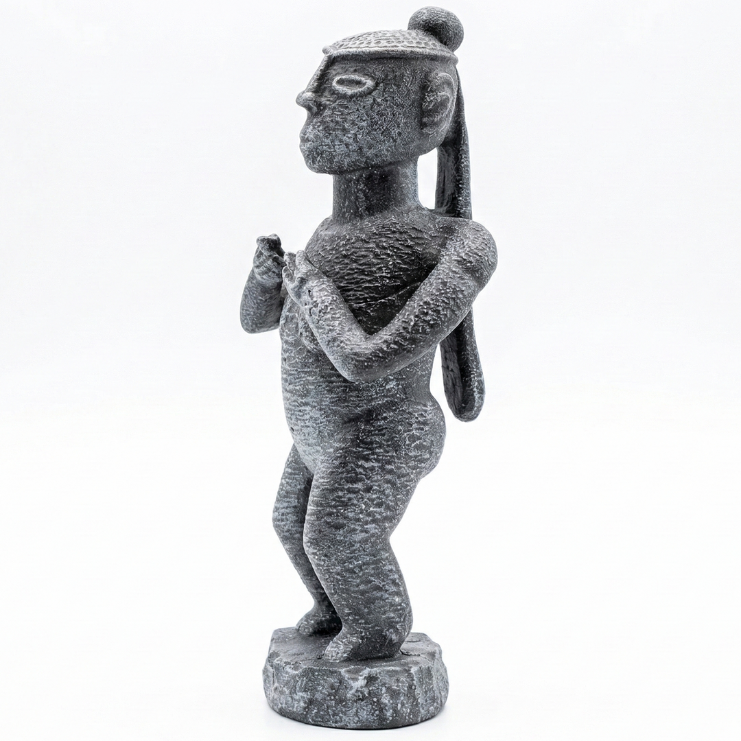 Senufo Kadın Ritüel Figürü taş renk Afrika heykeli ön çapraz açıdan görünüm. Batı Afrika Senufo kültüründen ilham alan stilize kadın figürü ve taş görünümlü yüzey dokusu ile Afrika sanat dekoru ve etnografik koleksiyon objesi by ArkeoArtDesign