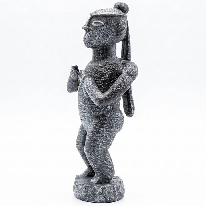 Senufo Kadın Ritüel Figürü taş renk Afrika heykeli ön çapraz açıdan görünüm. Batı Afrika Senufo kültüründen ilham alan stilize kadın figürü ve taş görünümlü yüzey dokusu ile Afrika sanat dekoru ve etnografik koleksiyon objesi by ArkeoArtDesign