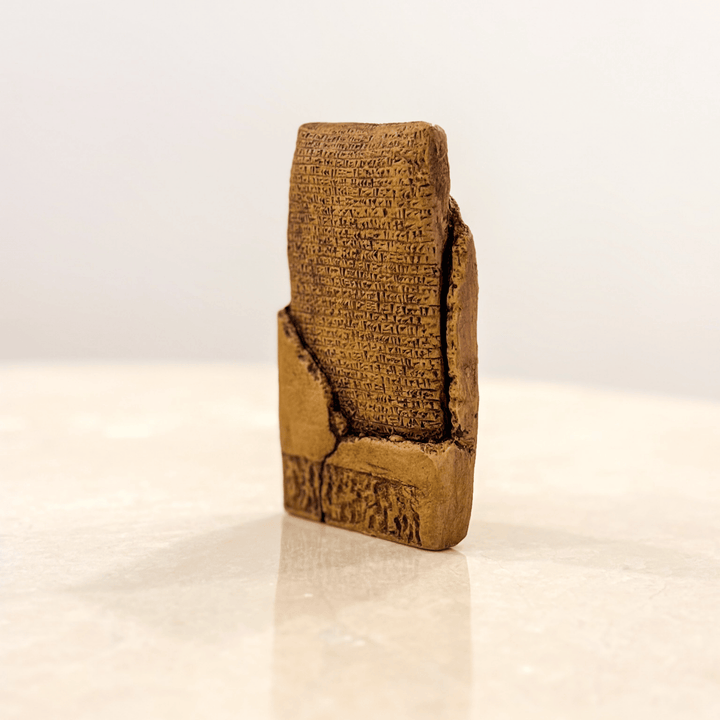 Bej tonlarında, yan perspektiften Sumerian Love Poem tableti. Cuneiform yazılı yüzey detayları, antik kil tablet dokusu, ahşap kaide. ArkeoArt imzalı el yapımı replika, Sümer uygarlığının aşk şiiri temalı eşsiz koleksiyon eseri.