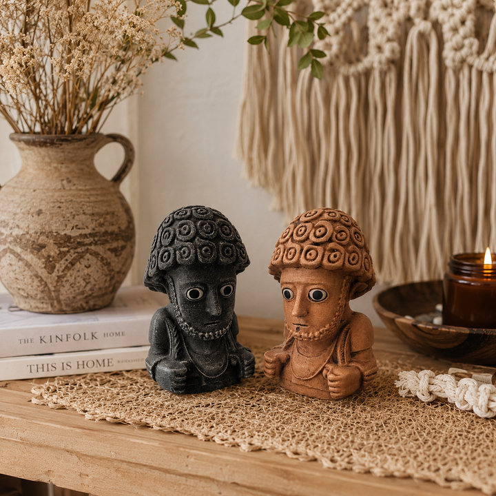 İki farklı renk seçeneğine sahip Suppiluliuma Hitit heykellerinin bohem tarz iç mekanda sergilendiği lifestyle görünüm. Museum-quality arkeolojik dekor objeleri; dark academia, antik Anadolu ve koleksiyon estetiğini modern yaşam alanlarına taşıyan el yapımı sanat heykelleri by ArkeoArt