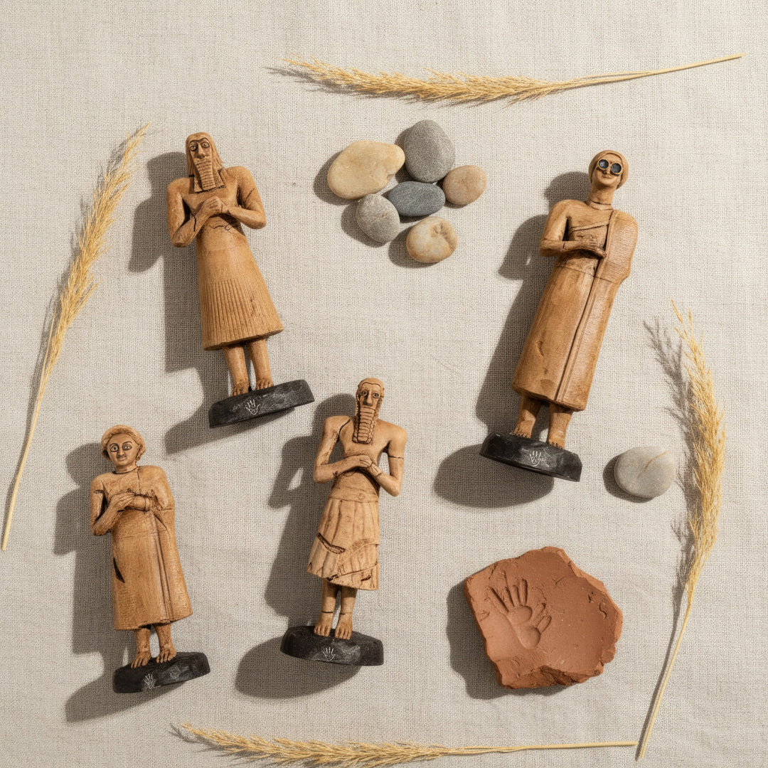 “Top-down view of the Sumerian Tell Asmar figurines arranged on a soft fabric surface — emphasizing harmony, symmetry, and the delicate craftsmanship of ancient votive art.”
TR: “Yumuşak kumaş dokusu üzerinde dizilmiş Sümer Tell Asmar figürlerinin yukarıdan çekimi — antik tapınma sanatının uyumunu, simetrisini ve zarif el işçiliğini vurgular.”