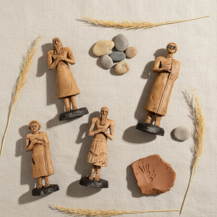 “Top-down view of the Sumerian Tell Asmar figurines arranged on a soft fabric surface — emphasizing harmony, symmetry, and the delicate craftsmanship of ancient votive art.”
TR: “Yumuşak kumaş dokusu üzerinde dizilmiş Sümer Tell Asmar figürlerinin yukarıdan çekimi — antik tapınma sanatının uyumunu, simetrisini ve zarif el işçiliğini vurgular.”