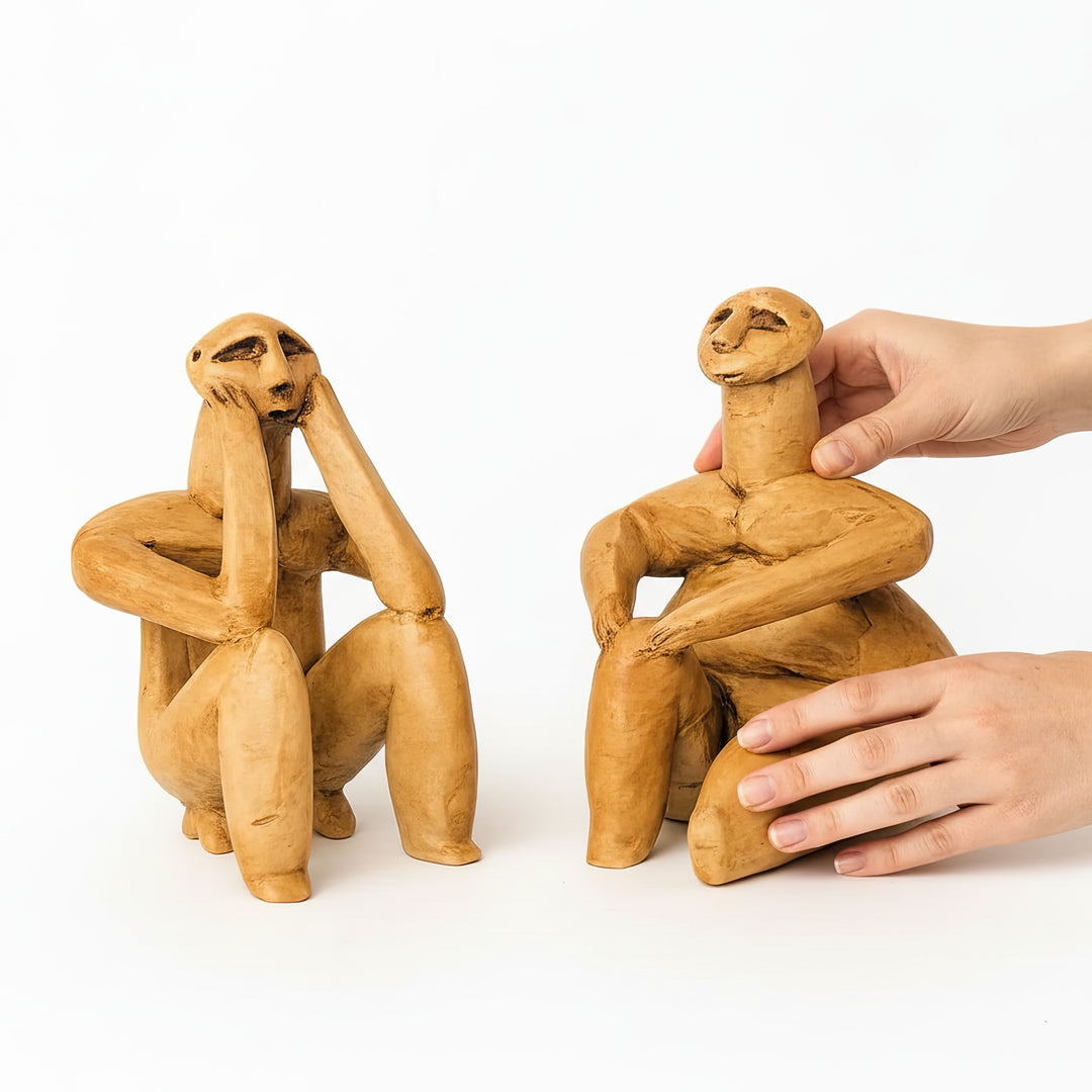 El ile tutularak ölçeklendirilmiş Hamangia figürleri – yaklaşık 15 cm yüksekliğinde, el yapımı Neolitik heykel seti. / Hand-held scale reference of Hamangia Thinker and Sitting Woman – handmade Neolithic figurine set approx. 6 inches tall, ArkeoArt handcrafted decor.