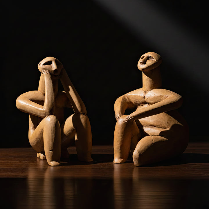 Siyah fon önünde Düşünen Adam ve Kadın figürleri – müze kalitesinde aydınlatmayla vurgulanmış detaylı arkeolojik sanat eseri. / Artistic studio lighting on Hamangia Thinker and Sitting Woman sculptures – museum-grade archaeological replicas by ArkeoArt, symbolic ancient decor