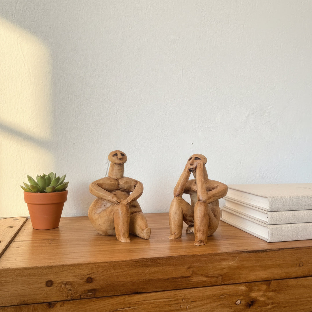 Kitap ve dekoratif objelerle birlikte sergilenen Düşünen Adam figür seti – akademik ve estetik bir atmosfer yaratır. / Hamangia figurines displayed beside books and ceramics – scholarly and aesthetic archaeological art arrangement, ArkeoArt handmade sculpture set.