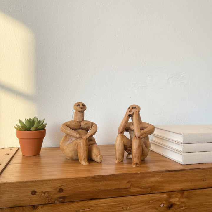 Kitap ve dekoratif objelerle birlikte sergilenen Düşünen Adam figür seti – akademik ve estetik bir atmosfer yaratır. / Hamangia figurines displayed beside books and ceramics – scholarly and aesthetic archaeological art arrangement, ArkeoArt handmade sculpture set.