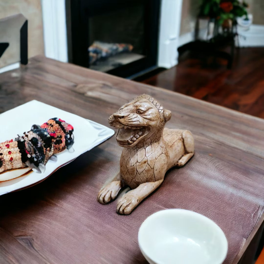 “The Urartian Lion Statue displayed on a rustic wooden shelf with dried flowers and antique books — creating a warm, historical atmosphere that blends archaeology and home art.”
TR:
“Kuru çiçekler ve antika kitaplarla süslenmiş rustik bir ahşap raf üzerinde sergilenen Urartu Aslanı heykeli; arkeoloji ve ev sanatını birleştiren sıcak, tarihî bir atmosfer yaratıyor.”