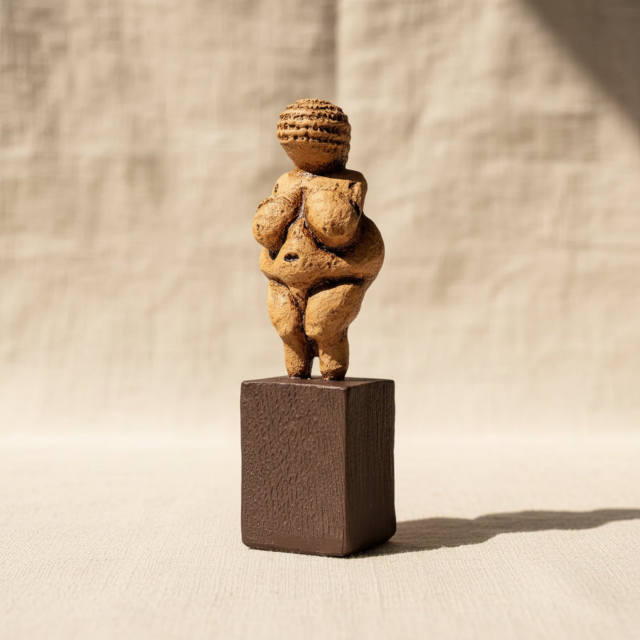 Willendorf Venüsü replikası yumuşak tonlarda arka plan ile çekilmiş dekoratif ürün fotoğrafı. Paleolitik dönemin ikonik doğurganlık tanrıçası figürü olan Venus of Willendorf heykeli, antik taş dokusunu yansıtan yüzeyiyle sergilenmektedir. ArkeoArt Paleolithic Venus replica, tarih öncesi sanat ve arkeoloji koleksiyonları için müze tarzı bir koleksiyon heykelidir.